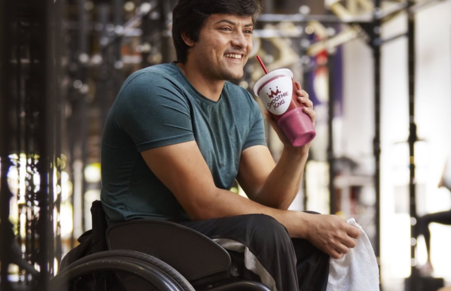 Athlete holding a smoothie in a wheelchair