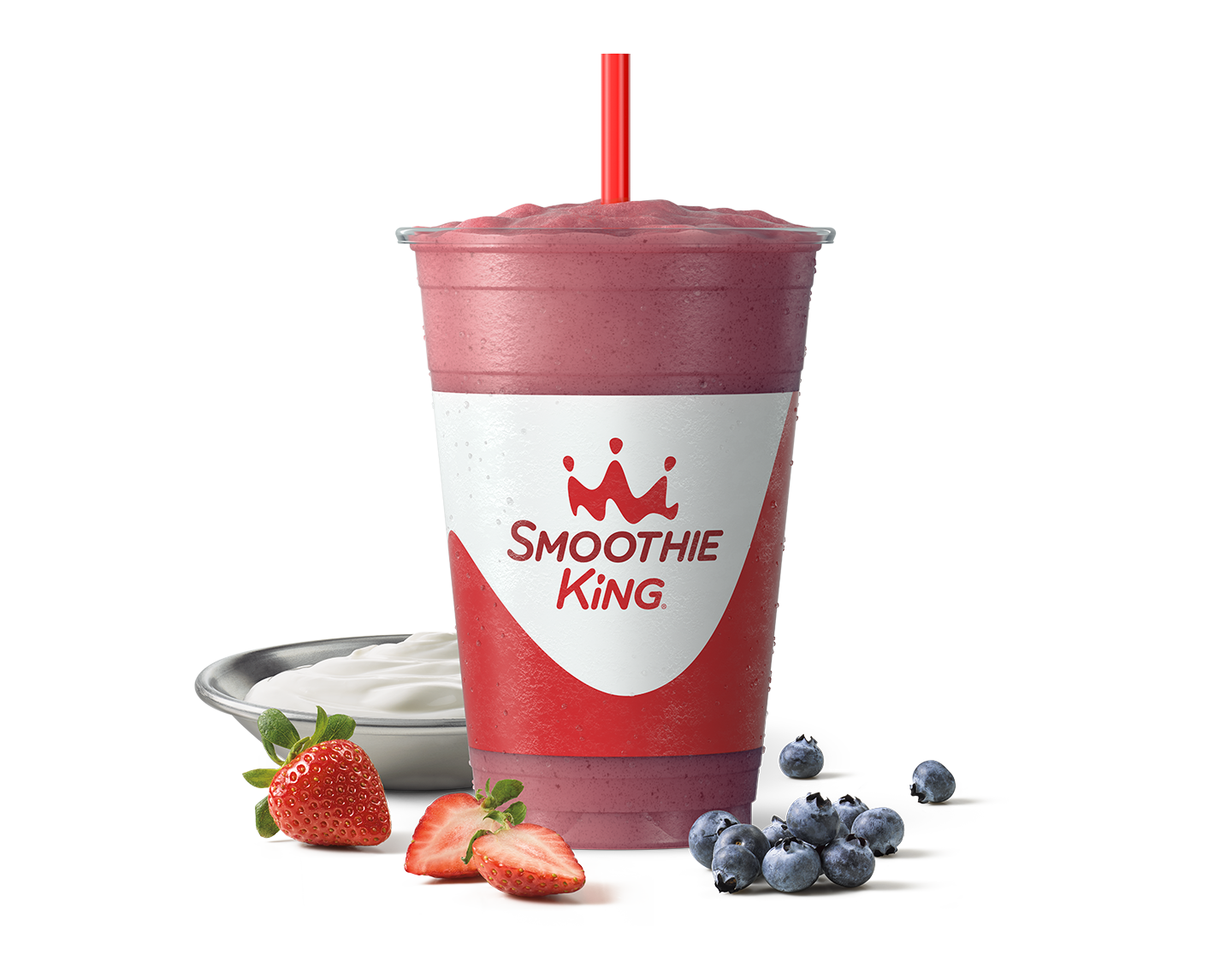 A healthy smoothie with blueberries and strawberries sitting beside it