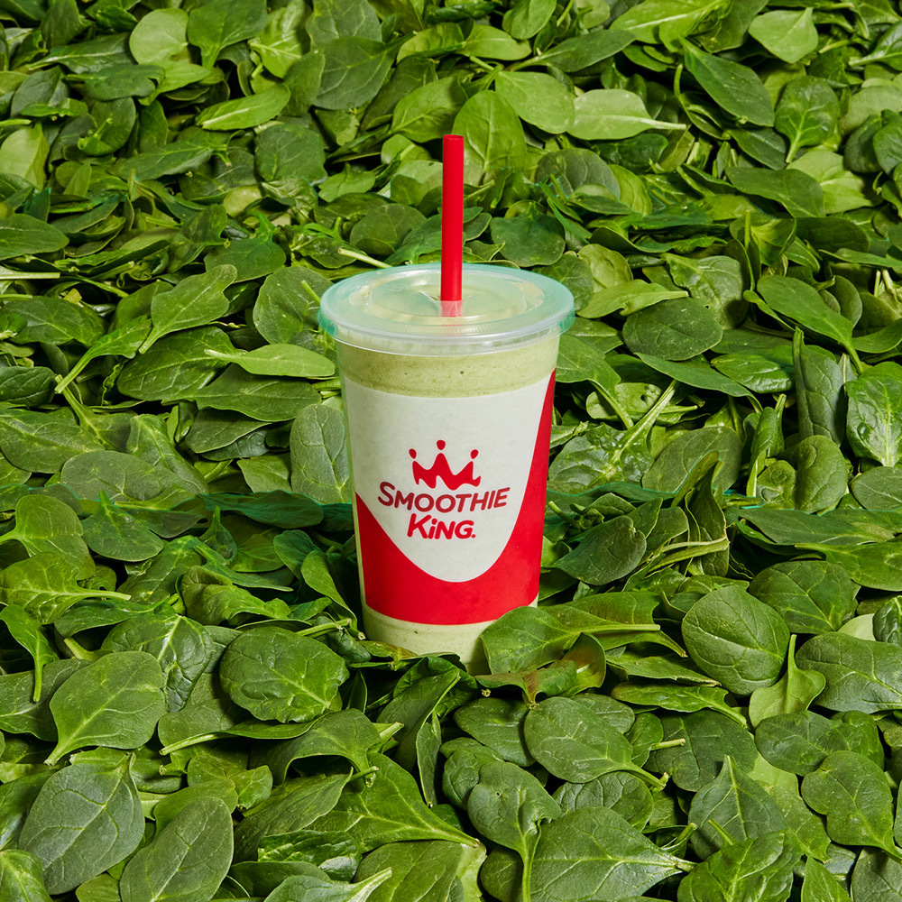 Smoothie King’s Clean Blends Spinach smoothie on a bed of fresh spinach