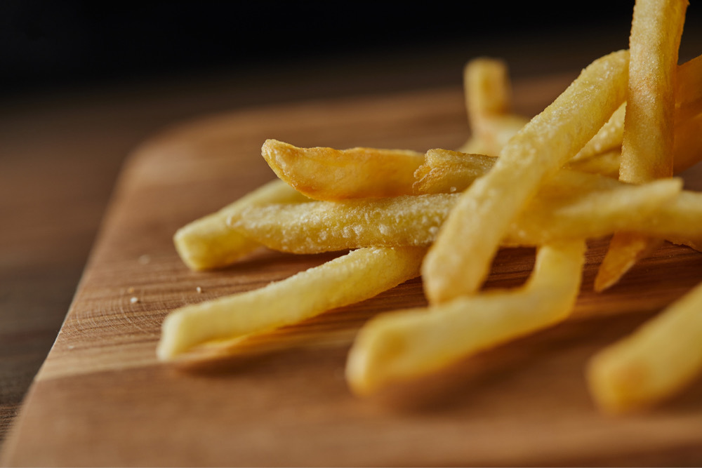 Salted french fries on a wooden cutting board