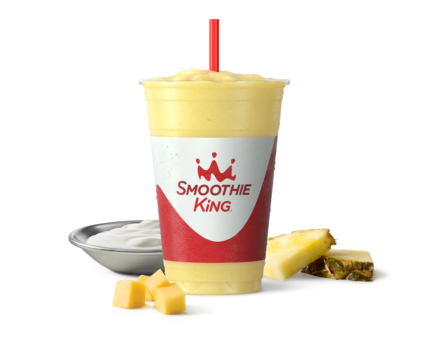 A healthy smoothie with mango chunks and sliced pineapple beside it